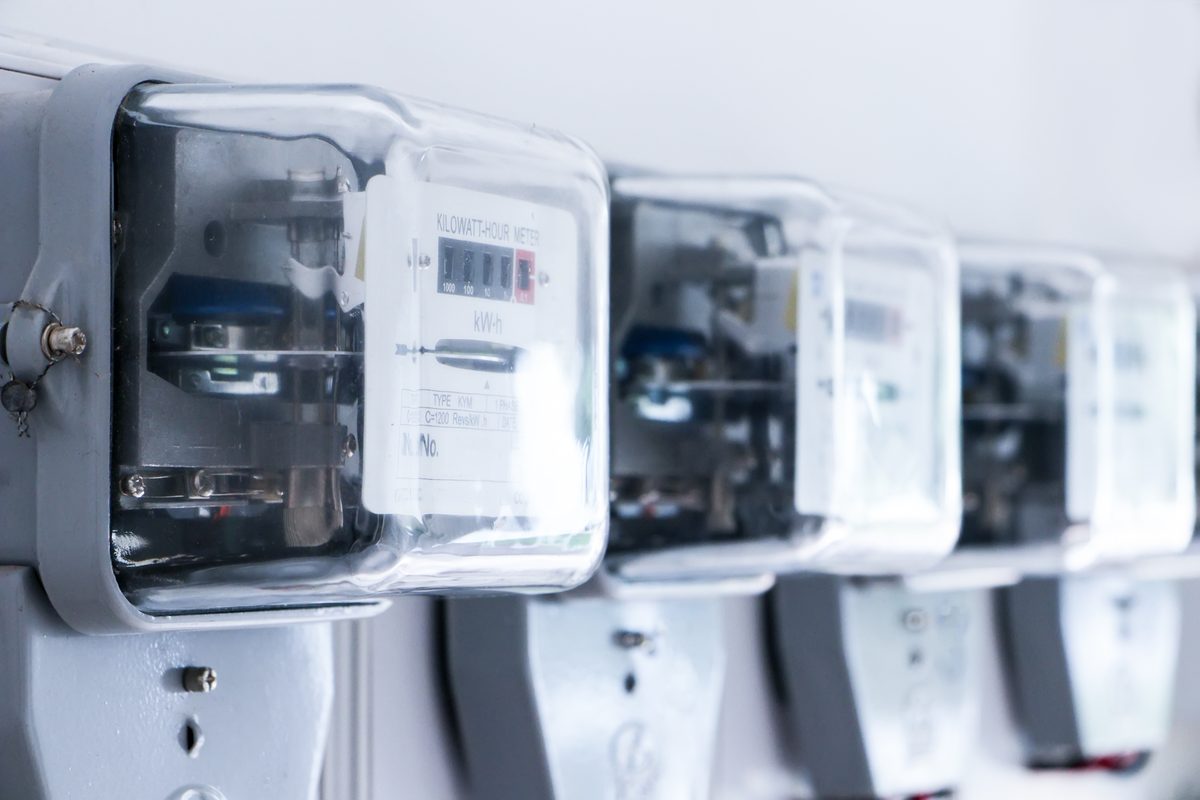 A row of electricity meters with clear covers, mounted side by side on a wall